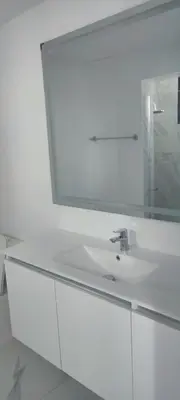 a white bathroom with a sink and a mirror at Penthouse in Cana Rock in Punta Cana