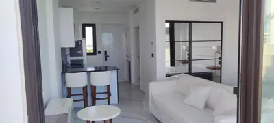 a living room with a white couch and a kitchen at Penthouse in Cana Rock in Punta Cana