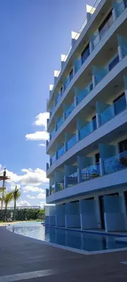 a building with a swimming pool next to a beach at Penthouse in Cana Rock in Punta Cana