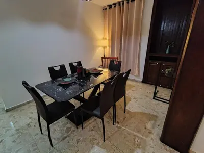a dining room table with black chairs and a table and a table and chairsktop at Comfortable and quiet double room in Santo Domingo