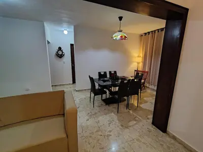 a living room with a dining room table and chairs at Comfortable and quiet double room in Santo Domingo