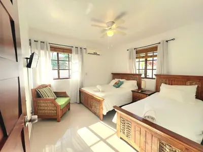 a bedroom with two beds and a chair in it at Apartamento Rosa Hermosa in Punta Cana