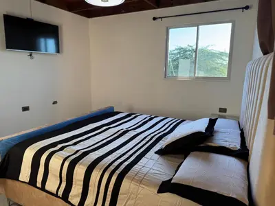 a bedroom with a large bed with a window at Terra Mia Villa in Pedernales
