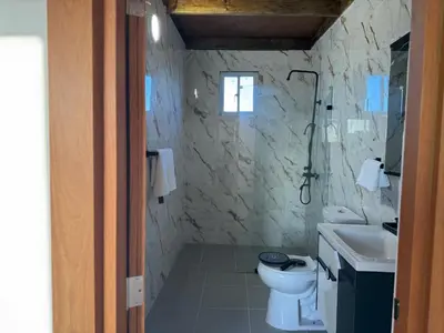 a bathroom with a toilet and a sink and a shower at Terra Mia Villa in Pedernales