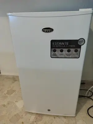 a white refrigerator with a sign on it at Private and comfortable double room in Santo Domingo