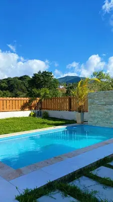 a swimming pool in a yard with a fence at Bello atardecer in Punta Cana