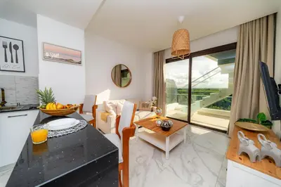 a kitchen and living room with a table and a dining room at Couples PH @ Cana Rock Star with Great Golf Views in Punta Cana