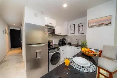 a kitchen with a stainless steel refrigerator and a dishwasher at Couples PH @ Cana Rock Star with Great Golf Views in Punta Cana