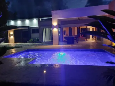 a swimming pool in front of a house at night at Villa Olam in Las Galeras