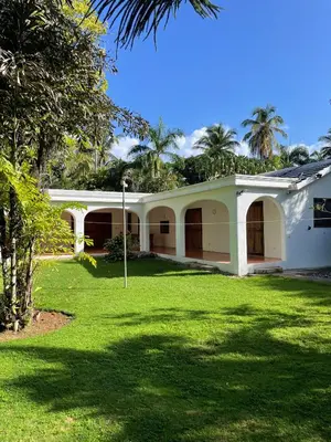 a white house with a green lawn in front of it at Villa Louana in Las Terrenas