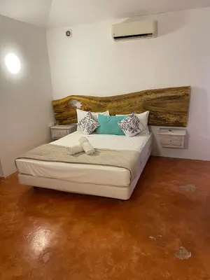 a bedroom with a bed with a wooden headboard at Villa Louana in Las Terrenas