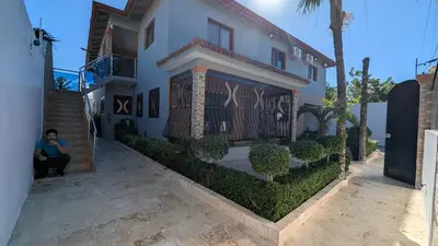 a man sitting in front of a house at Villa soñada 1 in Sosua
