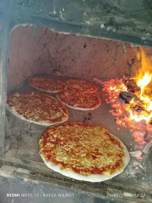 a group of pizzas cooking in a brick oven at Parador tropical in Las Galeras