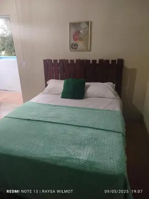 a bed with a green pillow on top of it at Parador tropical in Las Galeras