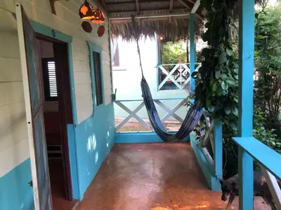 a room with a porch with a hammock and a dog at Casa Ylang Ylang 1, Playa Encuentro in Cabarete