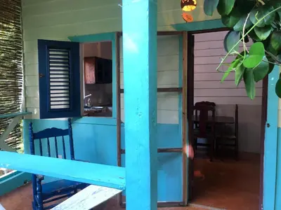 a room with a blue door and a kitchen at Casa Ylang Ylang 1, Playa Encuentro in Cabarete