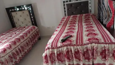 a bedroom with a bed with a remote control on it at This beautiful apt you can have a nice vacation in Santo Domingo