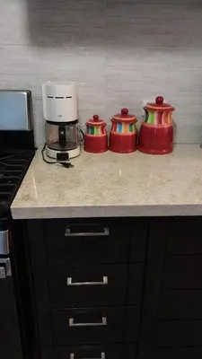 three red containers sitting on a counter in a kitchen at This beautiful apt you can have a nice vacation in Santo Domingo