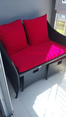a black wicker couch with red pillows in a room at This beautiful apt you can have a nice vacation in Santo Domingo