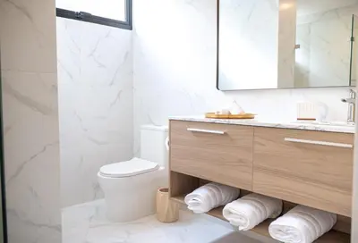 a bathroom with a toilet and a sink and a mirror at Modern & Cozy Luxury Suite with Amazing Views of STI in Santiago de los Caballeros