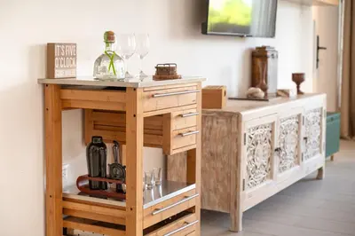a wooden table with wine glasses on top of it at Modern & Cozy Luxury Suite with Amazing Views of STI in Santiago de los Caballeros