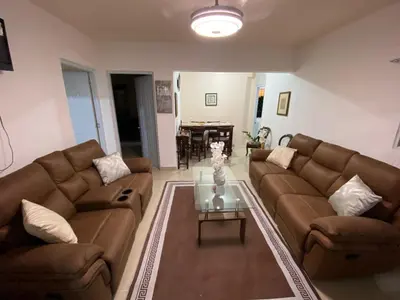a living room with two brown couches and a table at Casa amarilla in La Romana