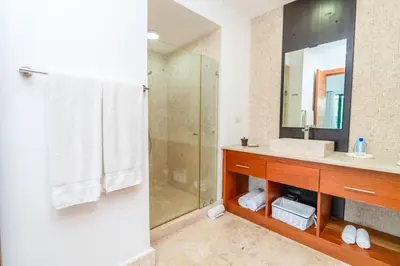 a bathroom with a shower and a sink and a mirror at Beachfront Sublime Las Terrenas in Las Terrenas
