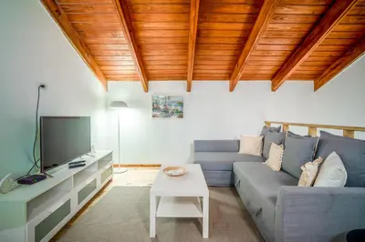 a living room with a blue couch and a tv at Beachfront Sublime Las Terrenas in Las Terrenas
