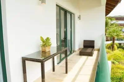a glass table on a balcony with a chair at Beachfront Sublime Las Terrenas in Las Terrenas