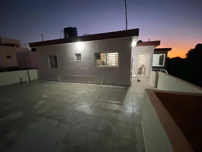 a large white building with a sunset in the background at Casa amarilla in La Romana
