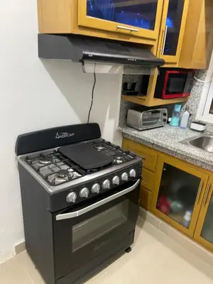 a kitchen with a black stove and a sink at Casa amarilla in La Romana