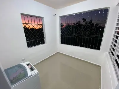 a room with two windows and a trash can at Casa amarilla in La Romana
