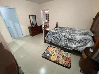 a bedroom with two beds and a mirror and a rug at Casa amarilla in Cumayasa Kilómetros 4 1/2