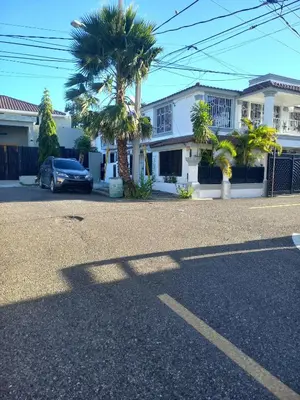 a car parked in front of a house with a palm tree at Casa Petter and Maria, 2end floor in Santiago de los Caballeros