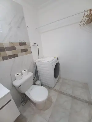a white bathroom with a toilet and a tv at Casa Petter and Maria, 2end floor in Santiago de los Caballeros