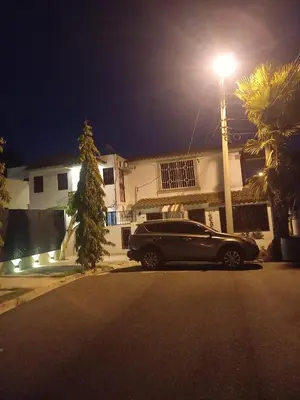 a black car parked in front of a house at night at Casa Petter and Maria, 2end floor in Santiago de los Caballeros