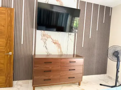 a dresser with a flat screen tv on top of it at Villa Rafael in Bayaguana