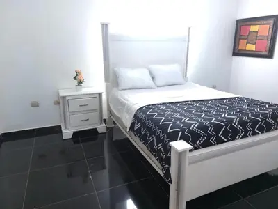 a bedroom with a bed and a nightstand with a bed sidx sidx at Villa Maryluz in Alto de los Castillos