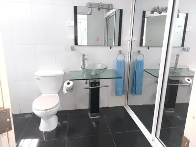 a bathroom with a toilet and a glass sink at Villa Maryluz in Alto de los Castillos