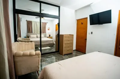 a bedroom with a bed and a mirror and a tv at A solo 5 minutos caminando del Puerto de Cruceros de La Romana Perfecto para trabajo remoto y descanso prolongado in La Romana