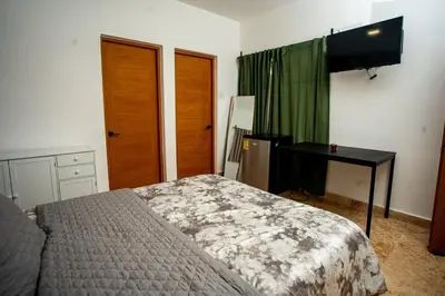 a bedroom with a bed and a desk and a television at A solo 5 minutos caminando del Puerto de Cruceros de La Romana Perfecto para trabajo remoto y descanso prolongado in La Romana