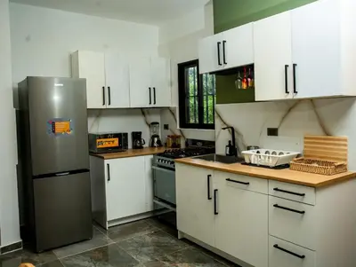 a kitchen with white cabinets and a stainless steel refrigerator at A solo 5 minutos caminando del Puerto de Cruceros de La Romana Perfecto para trabajo remoto y descanso prolongado in La Romana