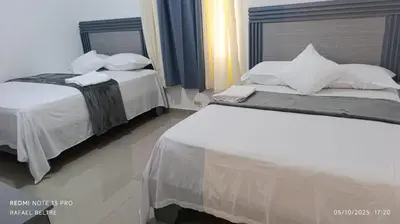 two beds sitting next to each other in a bedroom at Hotel a 500 de la playa in Pedernales