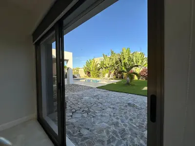 a sliding glass door with a view of a yard at Villa Olam - 9 pax, 4 min de la playa in Las Galeras