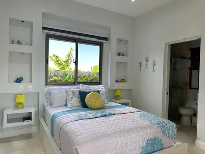 a white bedroom with a bed and a window at Villa Olam - 9 pax, 4 min de la playa in Las Galeras