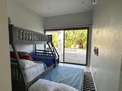 a bedroom with two bunk beds and a large window at Villa Olam - 9 pax, 4 min de la playa in Las Galeras