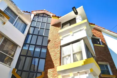 a tall brick building with white and yellow windows at Cozy apartment - steps from Playa Costambar in San Felipe de Puerto Plata