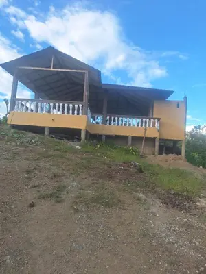 a building with a blue roof on top of a hill at Caribbean Corner in Jarabacoa