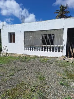 a white building with a gate and a window at Caribbean Corner in Jarabacoa