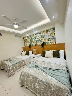 a bedroom with two beds and a painting on the wall at Las Olas Apartment, Juan Dolio in Guayacanes